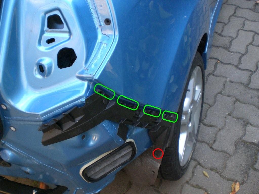 Unter der Verkleidung ist noch eine Schraube (rot), danach läst sich die Stoßstange ausklipsen (grün)